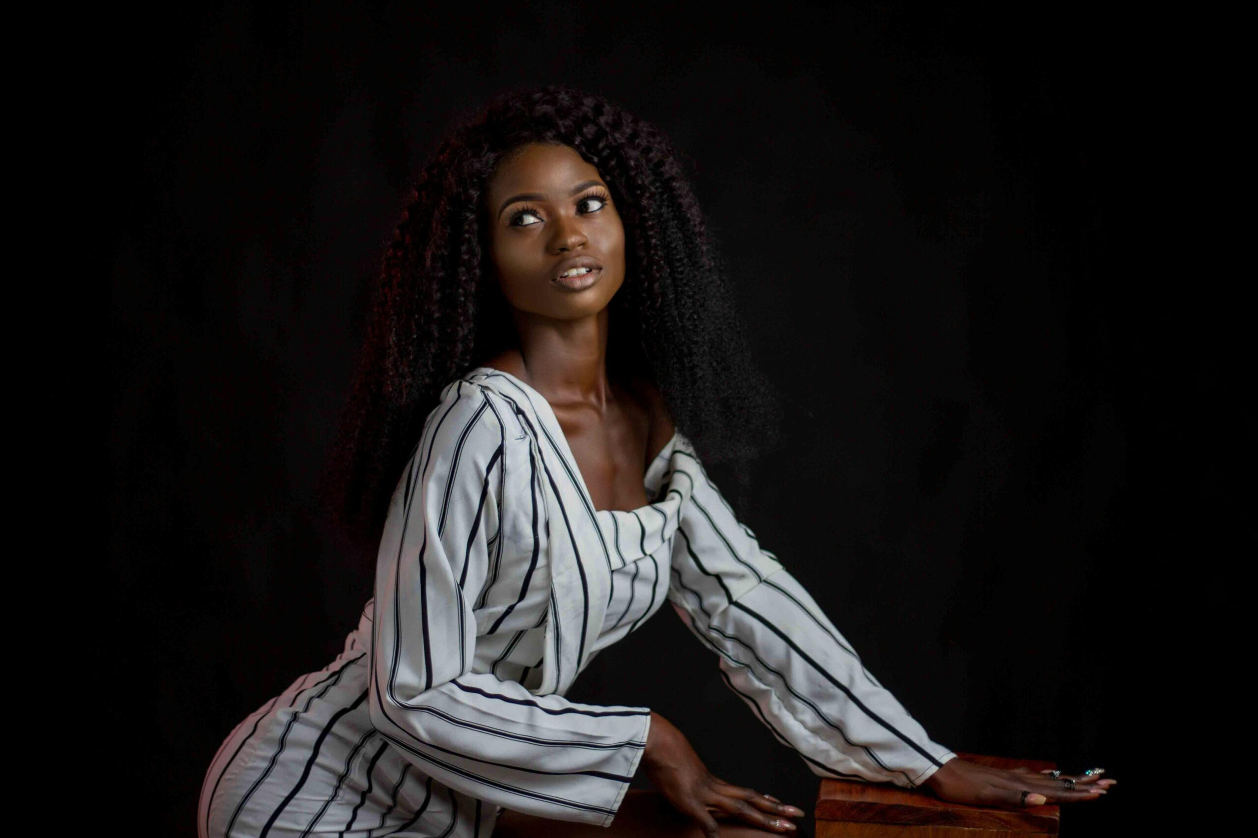 Beautiful portrait of a stylish woman in striped attire showcasing elegance and poise.
